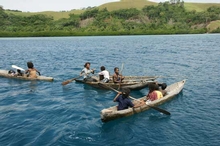 Villagers paddle their canoes out to offer fruit, vegetables, fish or handicrafts to trade