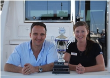 Riviera's Tony Schmid accepts the Bloodislow Cup from Zoe Bargh from the Red Cross Blood Service