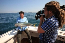 Mike Whitney with a king fish being filmed by the Sydney Weekender camera man