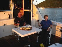 Graham and Biddy Stevenson enjoy a drink while anchored at Hexham Island, North Queensland